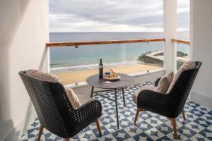 a balcony with a table and chairs and a view of the beach at Hotel Fariones in Puerto del Carmen