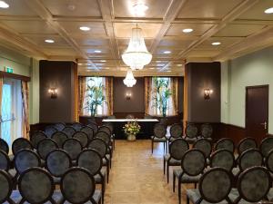 a conference room with chairs and a podium in the middle at Parkhotel Mastbosch Breda in Breda