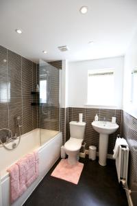 a bathroom with a toilet and a tub and a sink at Large Stylish Cambridge House (4BR/Free Parking) in Cambridge
