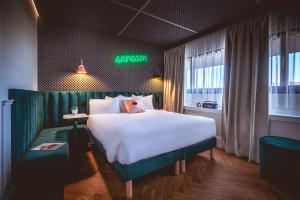 a hotel room with a large bed and a neon sign at The ReMIX Hotel in Paris