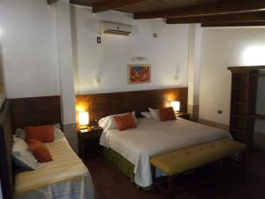 a hotel room with two beds and two lamps at Boutique Hotel De La Fonte in Puerto Iguazú