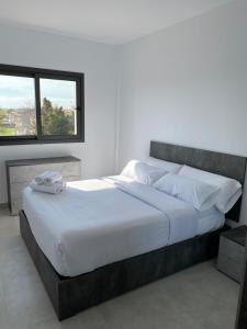 1 cama grande en un dormitorio con ventana en Apartamentos Giuliano, en Empuriabrava