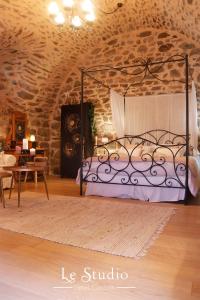een slaapkamer met een bed in een stenen kamer bij Le Studio in Entraygues-sur-Truyère