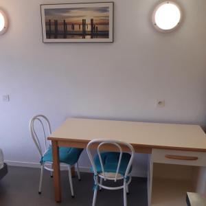 une table avec deux chaises et une photo sur le mur dans l'établissement BELLEVUE, à Quetigny