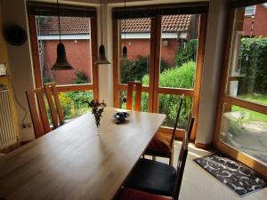 a dining room table with a vase of flowers on it at ABT Private Rooms Hannover Exhibition Ground (room agency) in Hannover