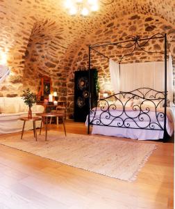 een slaapkamer met een bed in een stenen kamer bij Le Studio in Entraygues-sur-Truyère