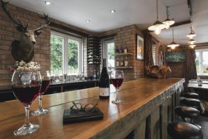 a bar with two glasses of wine on a counter at Lyth Valley Country House in Kendal