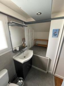 uma casa de banho com um lavatório e um WC em Le Cotin em Fécamp