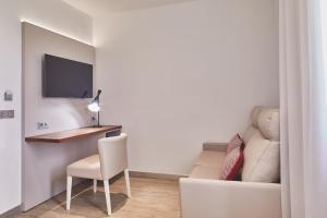 Habitación con escritorio, sofá y silla. en Silken Rona Dalba, en Salamanca