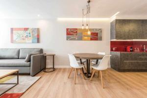 - un salon avec un canapé, une table et des chaises dans l'établissement Apartamento lujo princesa gran vía, à Madrid