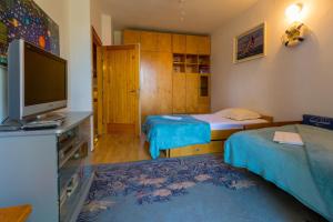 a small room with two beds and a television at DOBRINCIC in Selce