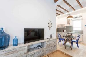 uma sala de estar com televisão e uma mesa com cadeiras em Apartamento de lujo nuevos ministerios chamberí em Madri