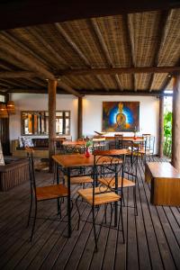 un comedor con mesas, sillas y una pintura en Tororao Hotel Pousada, en Arraial d'Ajuda