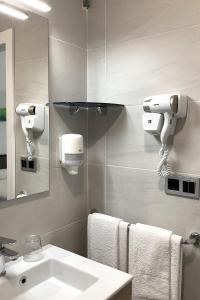 a bathroom with a sink and a mirror and towels at Pensión Donostiarra in San Sebastián