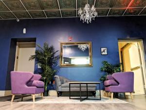 
a living room filled with furniture and a blue wall at City House New Orleans in New Orleans
