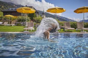 a person is falling into a pool of water at Hotel Saalbacher Hof in Saalbach-Hinterglemm