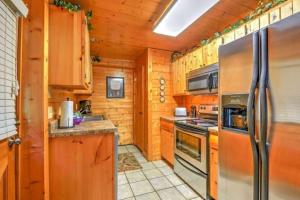 a kitchen with wooden cabinets and a stainless steel refrigerator at Smokey Max Cabin in Pigeon Forge