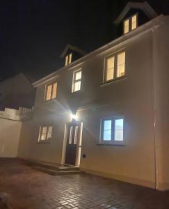 a white house at night with the lights on at Artro House in Pembrokeshire