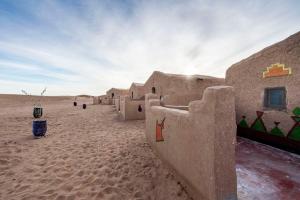 a group of buildings in the desert with a sky at Berber Camp & Desert Tours in Mhamid