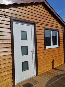 a house with a white door and two windows at Chalet du bien-être in Hornaing +1 photo