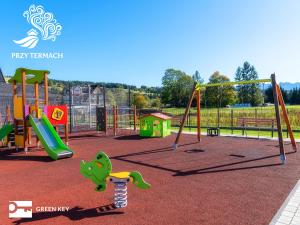 a playground with a swing set and a slide at Przy Termach Domki Pokoje Apartamenty in Szaflary