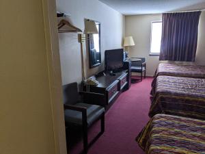 a hotel room with two beds and a television at Super 8 by Wyndham Shelbyville in Shelbyville
