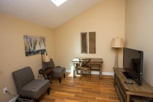 a living room with a television and a table and chairs at Lakeside 312 at Bluewater Bay in Niceville