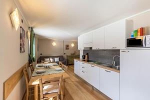 uma cozinha e sala de jantar com uma mesa e uma cozinha e uma sala de estar em Ice Chalet 3 Elements em Livigno