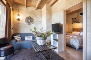 a living room with a blue couch and a bed at Pezoulia in Selakano