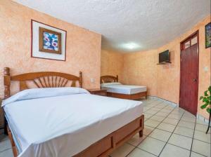 a bedroom with a bed and a tub and a sink at Hotel Fernando´s in Tlalpujahua de Rayón