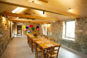 a long dining room with a long table and chairs at La Ferme du golf, gîte atypique et artistique in Lancieux