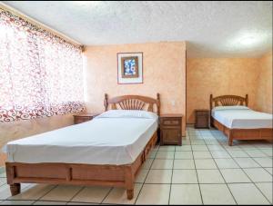 a bedroom with two beds and a window at Hotel Fernando´s in Tlalpujahua de Rayón