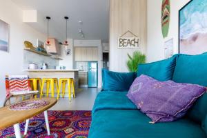 a living room with a blue couch and a kitchen at Apartamenty Your Seaside in Gdańsk