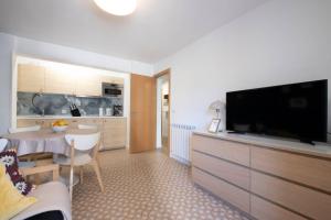 a living room with a flat screen tv and a kitchen at ACOGEDOR APARTAMENTO a 10 MINUTOS de la CIUDAD in Rentería