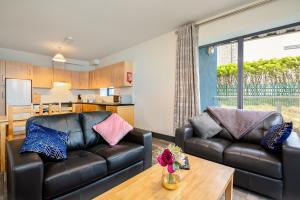 a living room with two leather couches and a table at Clarion Village in Sligo