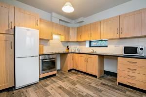 a kitchen with wooden cabinets and a white refrigerator at Clarion Village in Sligo