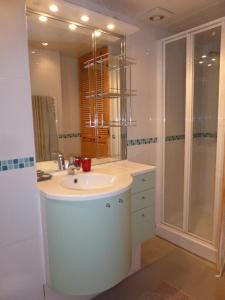 a white bathroom with a sink and a shower at Trouville sur mer vue sur la Touque in Trouville-sur-Mer
