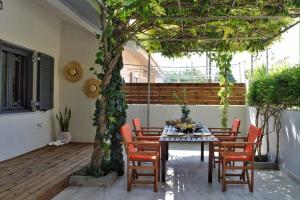 a patio with a table and chairs under a pergola at Onore in Lixouri
