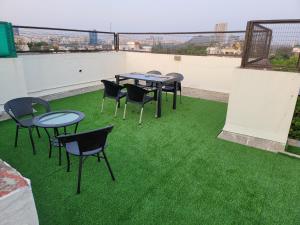 een patio met tafels en stoelen op een dak bij The Royal Luxury Stay in Pune