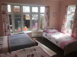 Postel nebo postele na pokoji v ubytování PINK HOUSE ,Opposite Beach ,SLEEPS 6 , 2 BEDROOM GROUND FLOOR SELF CONTAINED GARDEN FLAT , PRIVATE ENTRANCE , KITCHEN , Guaranteed Parking ,Wifi , Movies ,Bathroom ,fridge , microwave ,BEDROOM 1, DOUBLE BED & 2 SINGLE BEDS ,BEDROOM 2 , DOUBLE BED