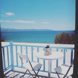 a table and chairs on a balcony with the ocean at Fisilanis Beachfront Hotel in Logaras