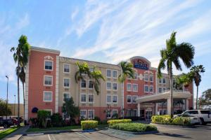 a hotel with palm trees in a parking lot at Baymont by Wyndham Miami Doral in Miami