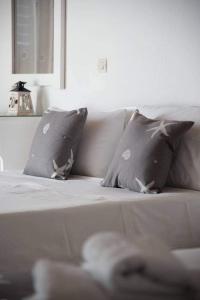 a white couch with two pillows on it at Fisilanis Beachfront Hotel in Logaras