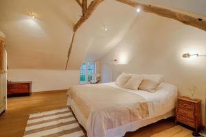 a bedroom with a large white bed and a window at Le Petit Tertre - charmante maison entre terre et mer - St Lunaire in Saint-Lunaire