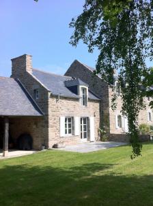 ein großes Backsteinhaus mit einem Rasenhof in der Unterkunft Le Petit Tertre - charmante maison entre terre et mer - St Lunaire in Saint-Lunaire