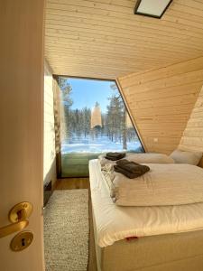 two beds in a room with a large window at Trasti & Trine Boutique Hotel in Alta