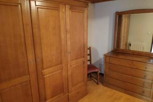 1 dormitorio con armario de madera y espejo en Casa do Marcolina en Salamonde