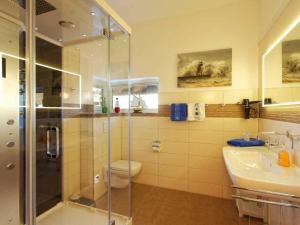 a bathroom with a shower and a toilet and a sink at Ferienhaus Kapitänsweg 30 in Ostseebad Karlshagen +18 photos