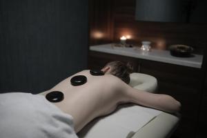 a man laying in a bath tub in a bathroom at Bacolux Diana Resort, Herculane in Băile Herculane