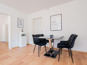 uma sala de jantar com uma mesa e cadeiras num quarto em EUPHORAS - Top ausgestattete Ferienwohnung mit 105 qm und 3 Schlafzimmern em Clausthal-Zellerfeld